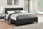 Bedroom with a black upholstered bed and decorative pillows.