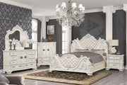 Elegant bedroom with white furniture, including a bed, dresser, and mirror, in a room with gray walls and decorative elements.