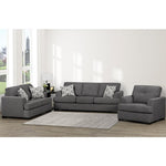 Gray sectional sofa with patterned cushions in a living room setting.