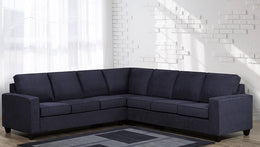 Sectional sofa in a living room with white brick wall and large window
