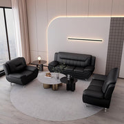 Modern living room with black leather sofa set and round coffee table.